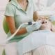 Dental cleaning professional - Unique Dental of Framingham Dental professional in mint scrubs and gloves works inside a patient’s open mouth with dental instruments.
