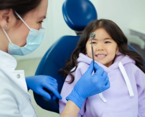 A dentist and a smiling child during a friendly dental check-up.