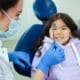 Framingham Family Dentist - Child Checkup - Unique Dental of Framingham A dentist and a smiling child during a friendly dental check-up.