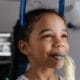 Framingham Family Dentist Keeps Smiles Healthy - Unique Dental of Framingham Young girl calmly undergoing a medical imaging procedure with laser alignment lines across her face and blue head support.