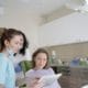 Choosing the Right Framingham Family Dentist - Unique Dental of Framingham Dental team reviewing a tablet with a patient seated in a dental chair in a modern clinic.